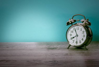 Ahşap masa üzerinde retro alarm saati olan eski bir arkaplan