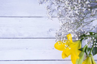 Mavi ahşap arka planda taze sarı çiçekler