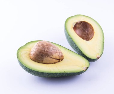 Beyaz arka planda iki dilim avokado izole edilmiş.