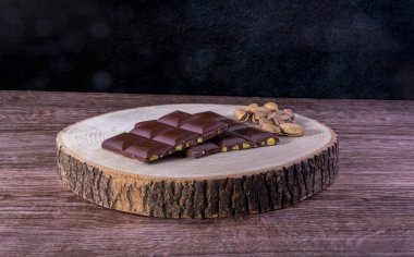 Tahta sehpanın üzerinde çikolata ve fıstık, ahşap zemin