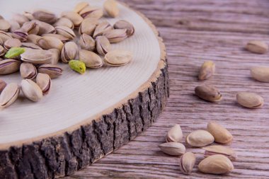 Ahşap masada fıstıklar ve ahşap arka planda