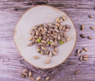 Ahşap masada fıstıklar ve ahşap arka planda