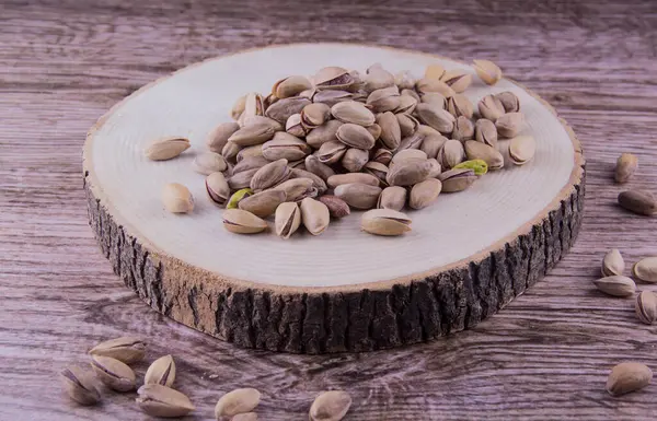 Ahşap masada fıstıklar ve ahşap arka planda
