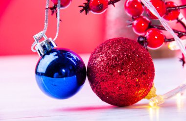 Kırmızı yeni yıl arka planında parlak kırmızı ve mavi noel ağacı süslemeleri