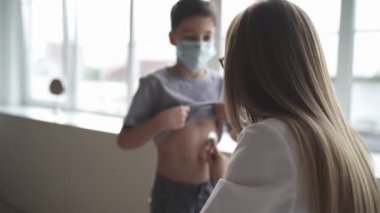 Pediyatrist doktor kadın üniforması kalp atışlarını izleyerek her yıl steteskop muayenesi yapıyor. Sağlık hizmetleri kavramı.