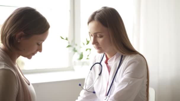 Mujer embarazada feliz visita médico ginecólogo en el hospital o clínica médica para el consultor de embarazo. El médico examinará el vientre del bebé y la madre embarazadas para verificar la atención médica. Concepto ginecológico. — Vídeos de Stock