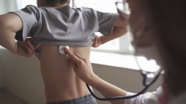 Pediyatrist doktor kadın üniforması kalp atışlarını izleyerek her yıl steteskop muayenesi yapıyor. Sağlık hizmetleri kavramı.