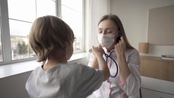 Kinderärztin Frau Uniform halten Stethoskop jährliche Kontrolle Kleinkind Junge durch Überwachung der Pulsfrequenz. Gesundheitskonzept.