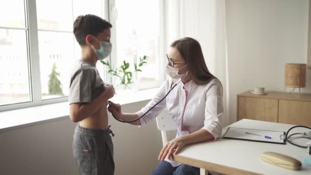 Kinderarts arts vrouw uniform houden stethoscoop jaarlijkse check-up peuter jongen door het controleren van de hartslag. Gezondheidszorgconcept. — Stockvideo