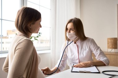 Mutlu hamile kadın, jinekolog doktoru hastanede ya da klinikte hamilelik danışmanlığı için ziyaret ediyor. Doktor, bebek ve anne sağlığı kontrolü için hamile karnı muayene ediyor. Jinekoloji konsepti