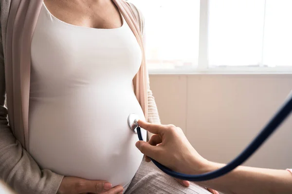 Wanita hamil yang bahagia mengunjungi dokter kandungan di rumah sakit atau klinik medis untuk konsultan kehamilan. Dokter memeriksa perut hamil untuk pemeriksaan kesehatan bayi dan ibu. Konsep ginekologi — Stok Foto