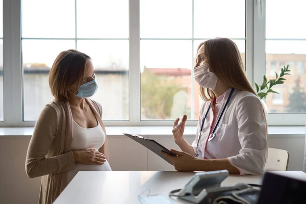 Wanita hamil yang bahagia mengunjungi dokter kandungan di rumah sakit atau klinik medis untuk konsultan kehamilan. Dokter memeriksa perut hamil untuk pemeriksaan kesehatan bayi dan ibu. Konsep ginekologi — Stok Foto