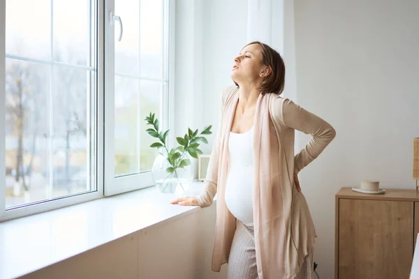 Sjukvård, behandling. Ung gravid kvinna känner plötslig smärta i ryggen. Framtida mamma som lider av ryggsmärta. — Stockfoto