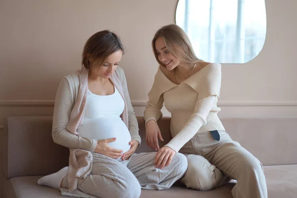 Gülümseyen kadın hamile sevgilisinin karnına dokunuyor.