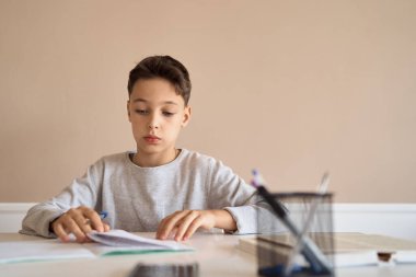 Uzaktan öğrenme çevrimiçi eğitim. Bir okul çocuğu evde ders çalışır ve okul ödevi yapar. Evden öğrenme.