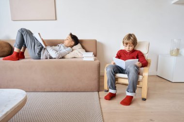 Çocuklar evde oturup kitap okuyorlar.