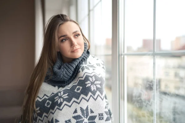 Omtänksam lugn lyhörd ung kvinna sitter på fönstret tröskel hemma insvept i varm bekväm tröja — Stockfoto