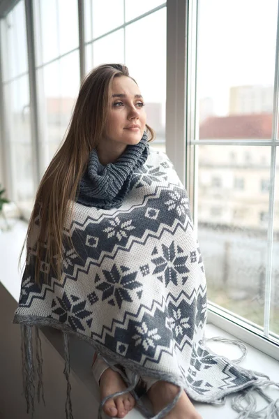 Omtänksam lugn lyhörd ung kvinna sitter på fönstret tröskel hemma insvept i varm bekväm tröja — Stockfoto
