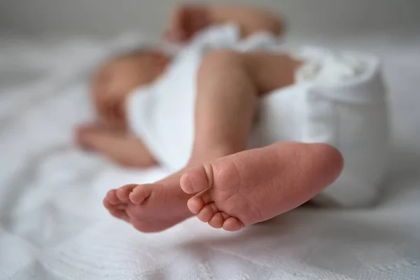 Uma semana bebê adorável recém-nascido deitado na baioneta e bocejo engraçado.Retrato de criança dormindo caucasiano cansado na cama. — Fotografia de Stock