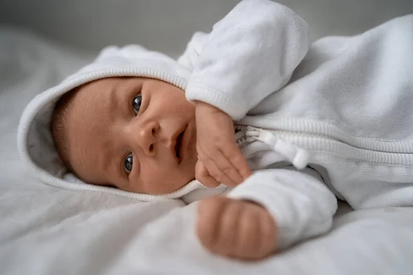 En vecka nyfödd förtjusande baby liggande vid bajskorg och rolig gäspning.Porträtt av sömniga kaukasiska spädbarn trött barn på sängen. — Stockfoto