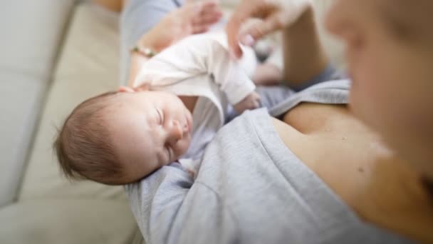 Jovem mãe feliz segurando seu bebê recém-nascido em seus braços — Vídeo de Stock