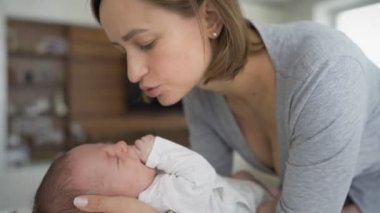 Anne ve çocuk. Anne sakinleşir, ağlayan yeni doğmuş bir bebeği kucağına alır. Anneler Günü