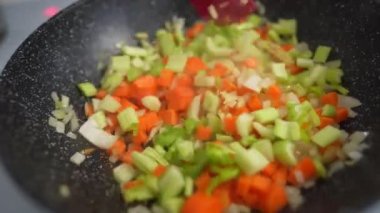 Rengarenk buharlı sebzelerin tavada kızarmasını ve karıştırılmasını yakından izleyin. Yemek pişirme, sağlıklı yemek, vejetaryen mutfağı. Lezzetli tat, ev yapımı yemek..