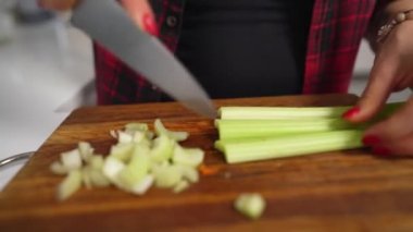 Kadın ev yapımı sebze salatası pişirmek için kereviz kesiyor.