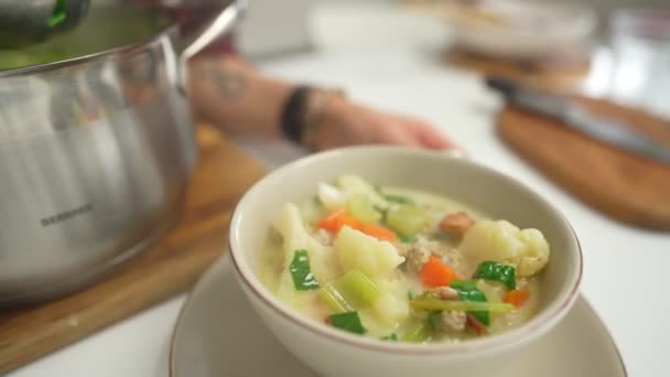 Mulher serve uma saborosa sopa de legumes com spianch — Vídeo de Stock
