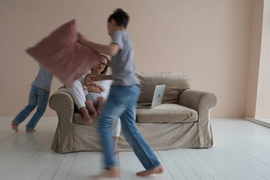 Oğulları etrafta koşuşturup bağırırken bekar bir anne tavan arasında dizüstü bilgisayarda oturuyor..