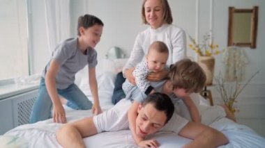 Üç çocuklu bir aile yatakta eğleniyor. Mutlu aile kavramı. Babalar Günü