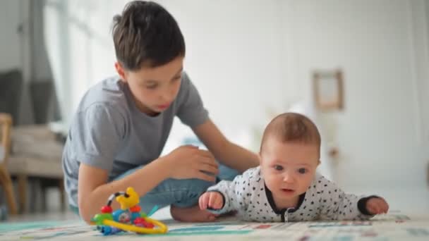 Lillebror sitter med sin lillebror. Småbarn Familj med barn hemma — Stockvideo