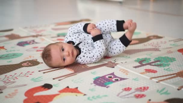 Bebê primeiro virar exercício. Bebé bonito vire a barriga no tapete — Vídeo de Stock
