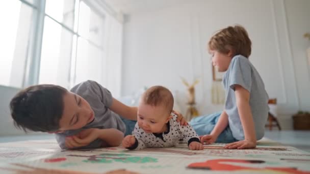 Lillebröder sitter med sin lillebror. Småbarn är barnvakter. — Stockvideo