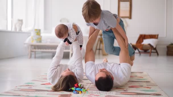 Glimlachend gezin op de vloer in de woonkamer. Een grote gelukkige familie met kinderen die poseren voor de camera op de vloer — Stockvideo
