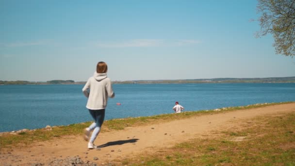 Ung frisk kvinna jogga på stranden på solig dag. — Stockvideo