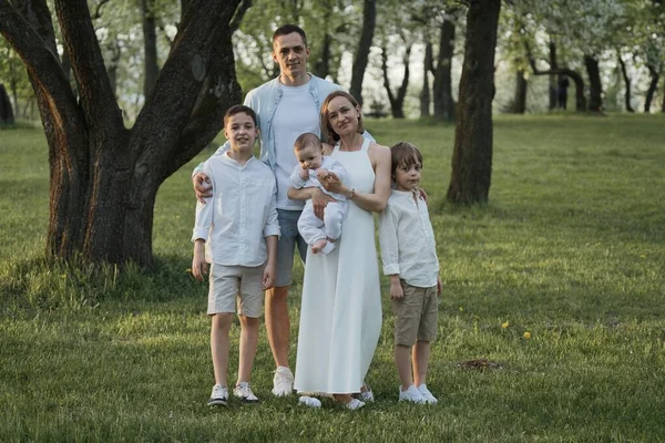 Famille heureuse avec trois enfants mâles posant dans le parc. — Photo