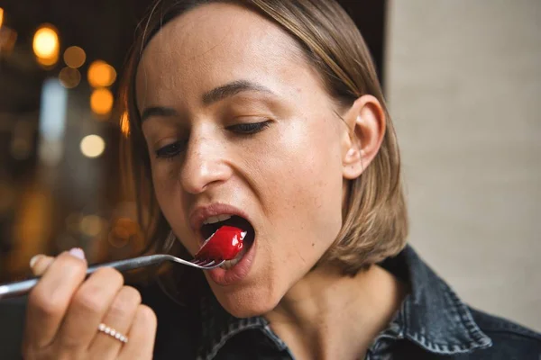 Porträtt av en ung kvinna som äter dessert på ett café. — Stockfoto