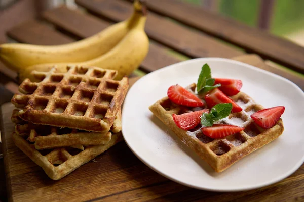 Closeup view of breakfast belgium waffles with strawberry and banana with mint on wooden background — Stock Photo, Image