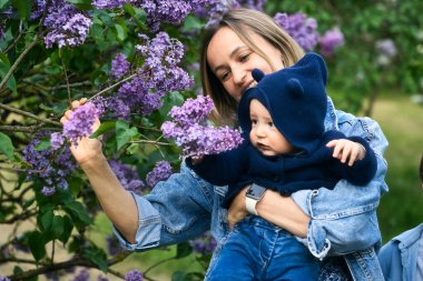 Mutlu anne ve oğul çiçek açan leylakların bahçesinde