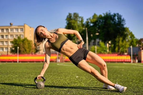 Femme sportive faisant de la musculation avec kettlebell en plein air — Photo