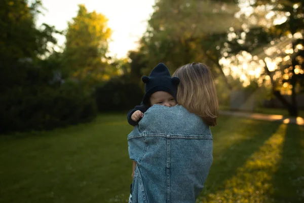 Mère vomit bébé, jouer et rire au soleil jour d'été sur la nature. Famille heureuse en plein air. — Photo