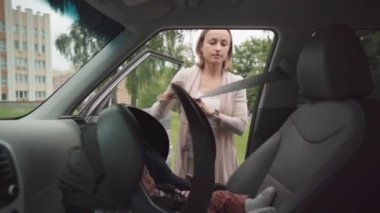 Genç anne, bebek koltuğuna oturuyor. Çocuğu güvenli bir yere götürüyor. Yolculuk için sorumluluk sahibi bir ebeveyn, bebeklerin güvenliğine bakıyor.