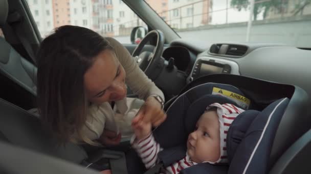 Mère conduisant la voiture avec son bébé dans le siège auto. — Video