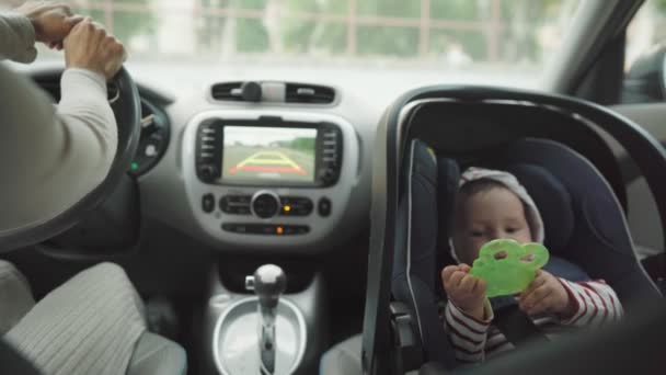 Mère conduisant la voiture avec son bébé dans le siège auto. — Video