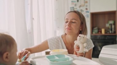 Ebeveynler çocuğu muz dilimleriyle besler. Çocuğun ilk tamamlayıcı yiyeceği.