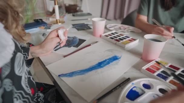 Primo piano di mani femminili che disegnano un pappagallo su un foglio di carta in colori diversi. Resta a casa, idea di gioco. Classe di padrone in disegno — Video Stock