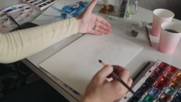 El primer plano de las manos femeninas dibujando el papagayo en la hoja del papel en los colores diferentes. Quédate en casa, concepto de juego. Clase magistral de dibujo — Vídeo de stock