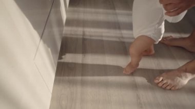 Bebek ilk adımı atıyor. Baba çocuğu kucağına alır ve geçindirir ve ona evde yürümeyi öğretir. Bir çocuğun hayatının ilk yılı.