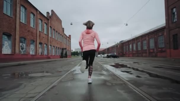 젊은 여성 이 도시의 오래 된 거리를 달리고 있습니다. 뒷 쪽을 봐. 성공 과 목표를 이루는 길로 가고 있습니다. 대조 사진. — 비디오